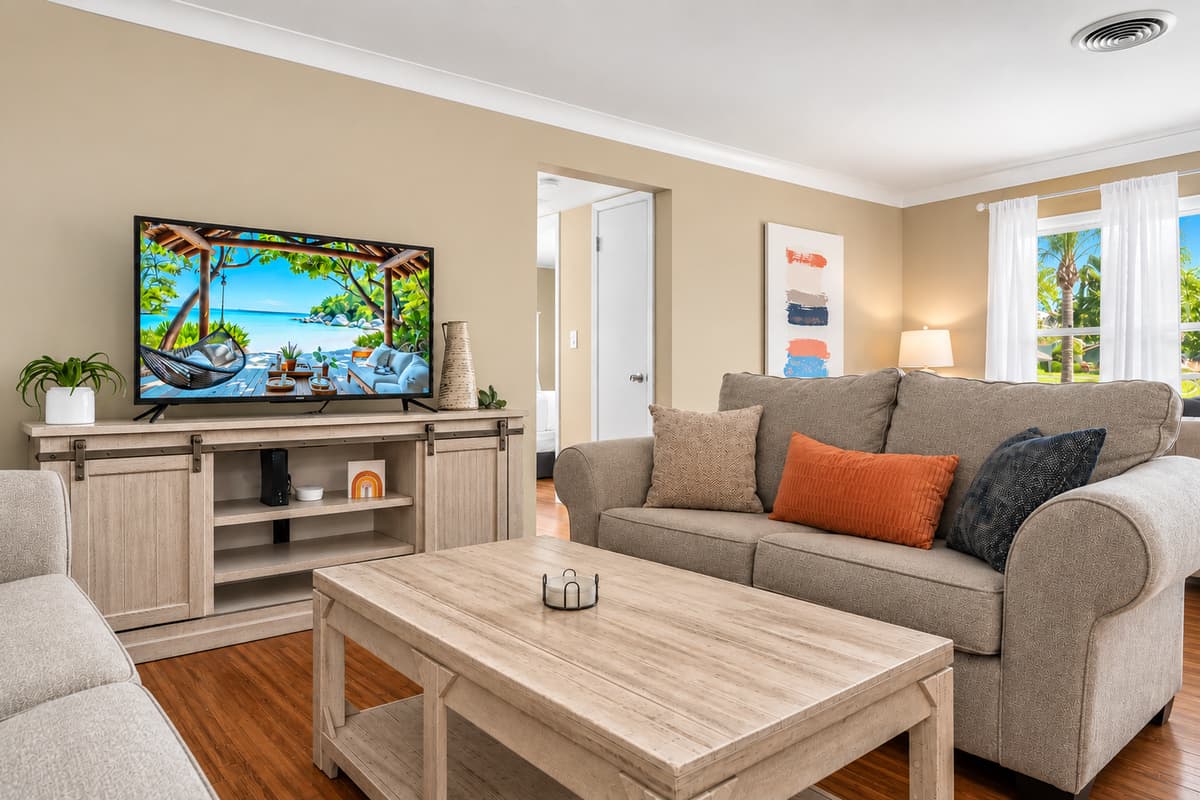 Comfortable entertainment area with a large TV, plush seating, and relaxing coastal-inspired décor.