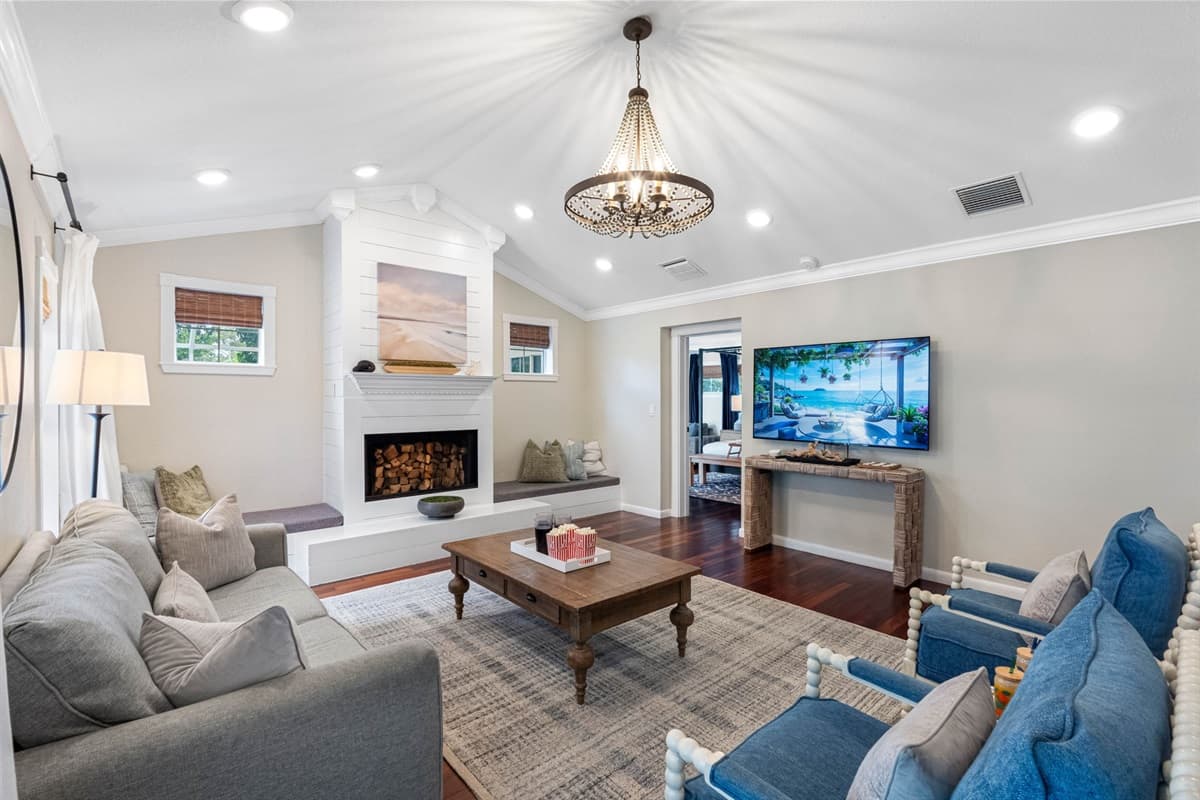 Modern touches, including recessed lighting and a mounted TV, complement the traditional charm of the wood-burning fireplace.