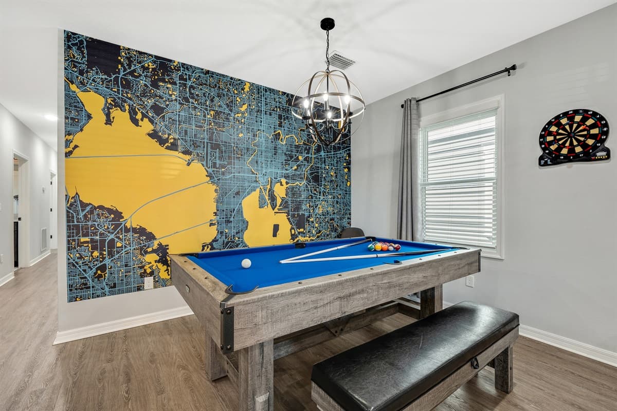 At the heart of the game room stands the centerpiece - a convertible pool table seamlessly transformed into a ping pong table.
