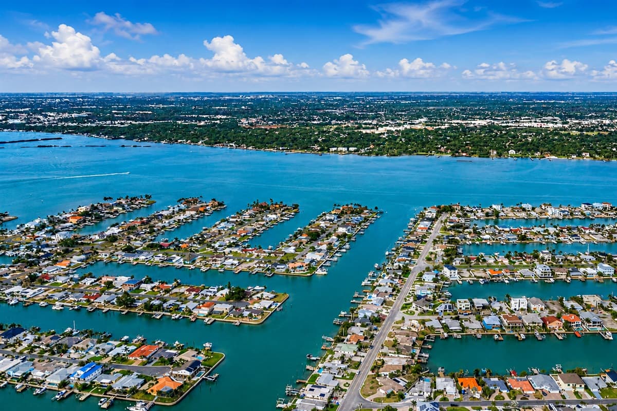 Coastal aerial view highlighting the beach, waterways, and surrounding island community.

