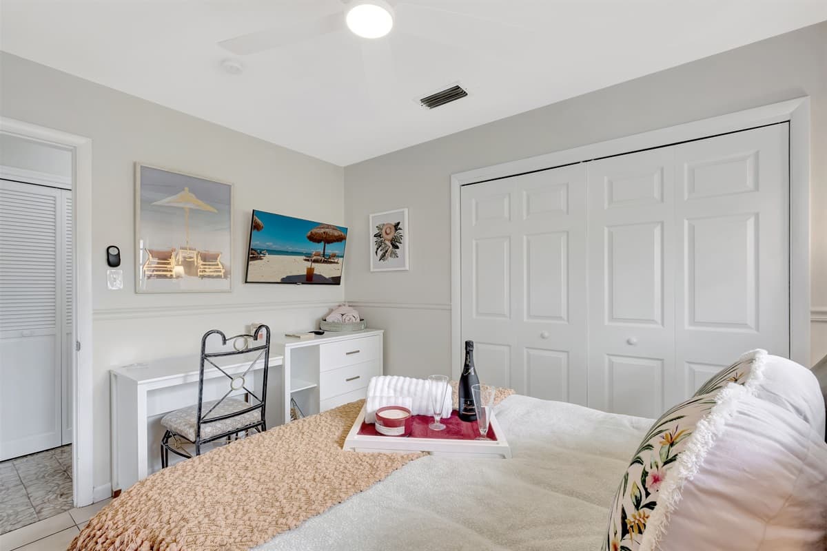 This bedroom provides a spacious, well-lit ambiance along with a comfortable queen-size bed.