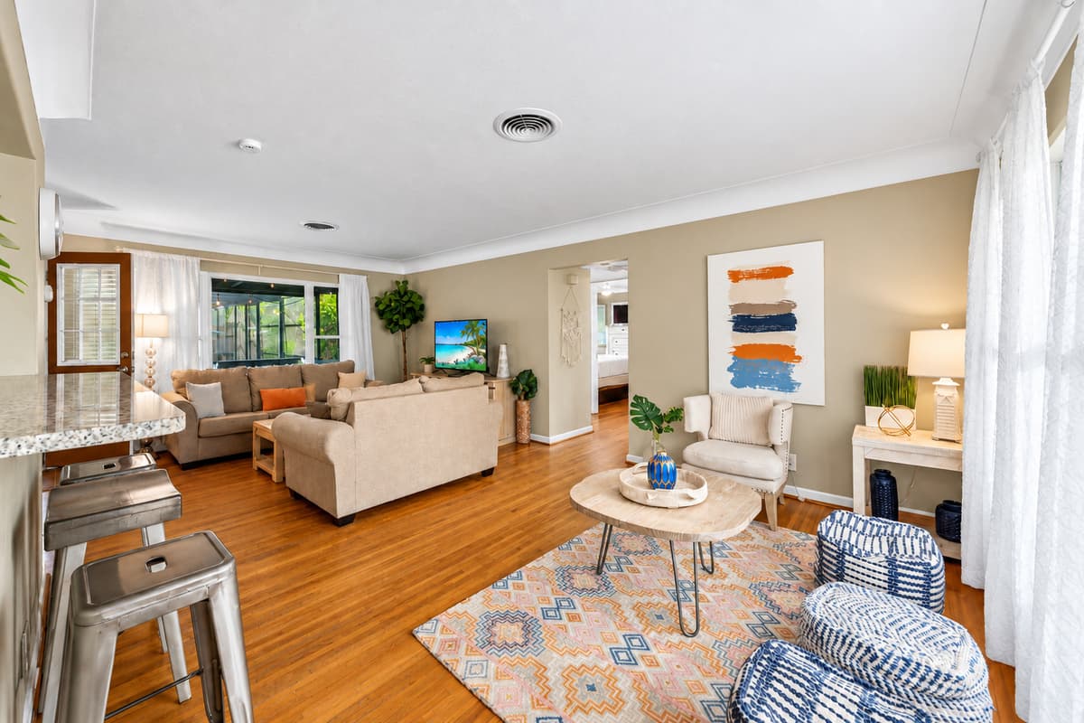 Spacious open-concept living area featuring comfortable sofas, large windows, and plenty of natural light.