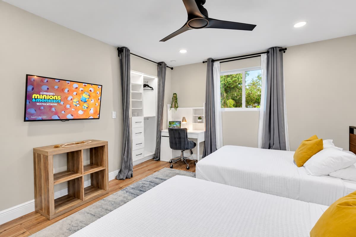 Two queens, bold art, and a door that closes. Bright and comfortable with a smart TV, open shelving and a window onto the garden — a room with personality, not just extra beds.
