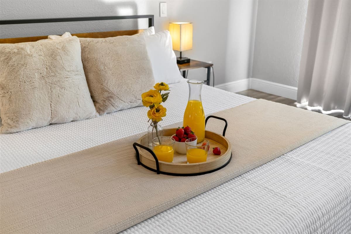 Unwind in the serene master bedroom with sleek décor, warm lighting, and private ensuite.