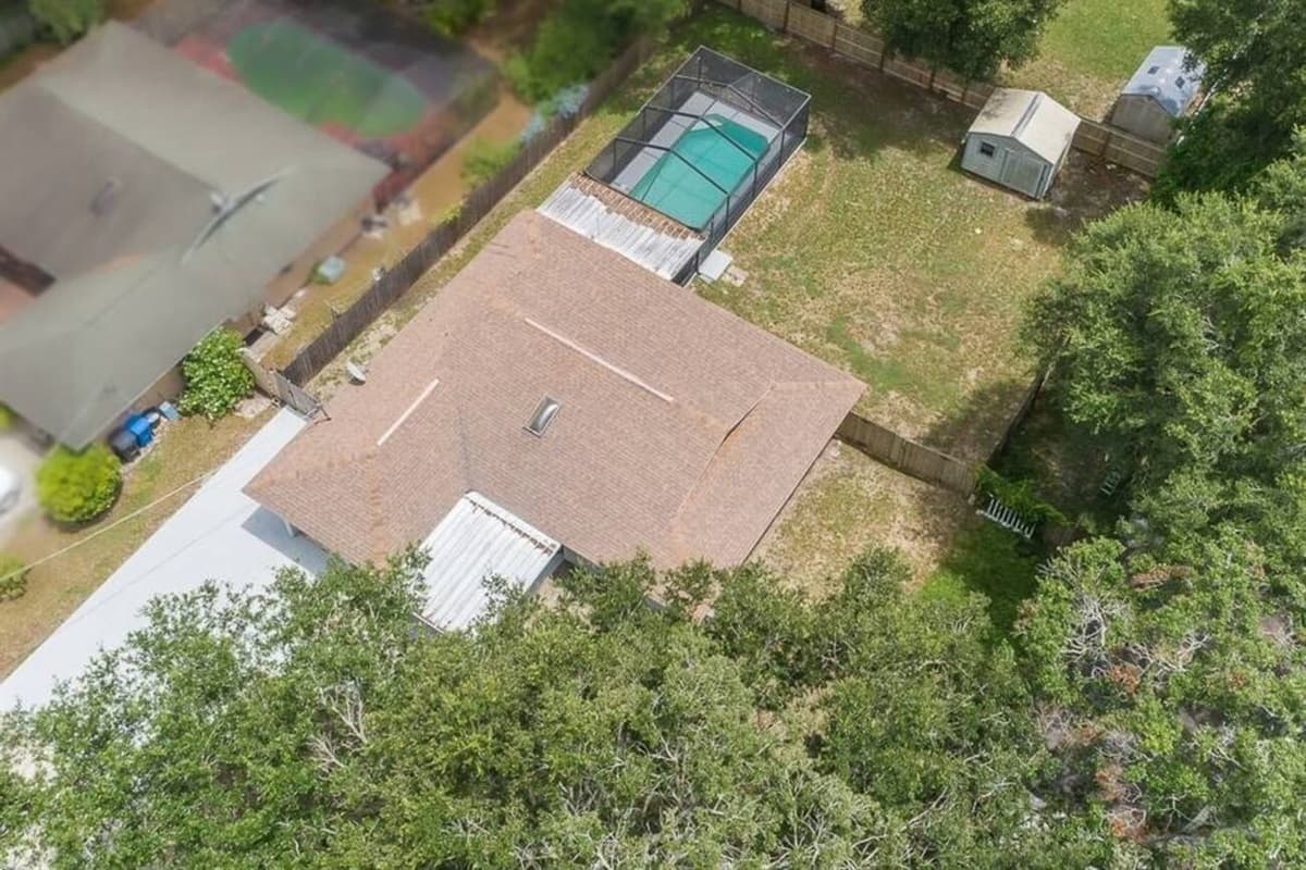 Aerial side profile of the property showcasing the beautiful fully fenced backyard, our immaculate heated pool and spacious driveway. If you are interested in this property, send us an inquiry as soon as possible!