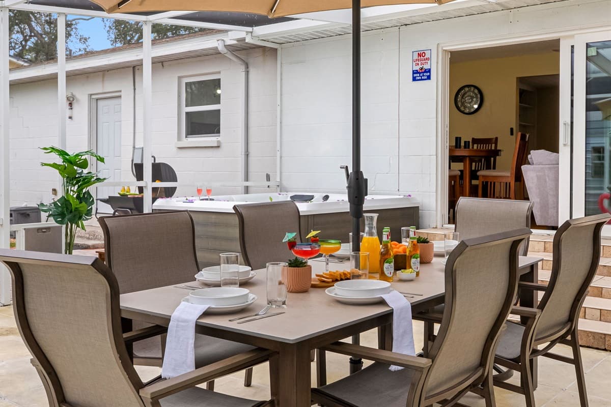 Relax poolside while enjoying outdoor dining with ample seating and a shaded umbrella.