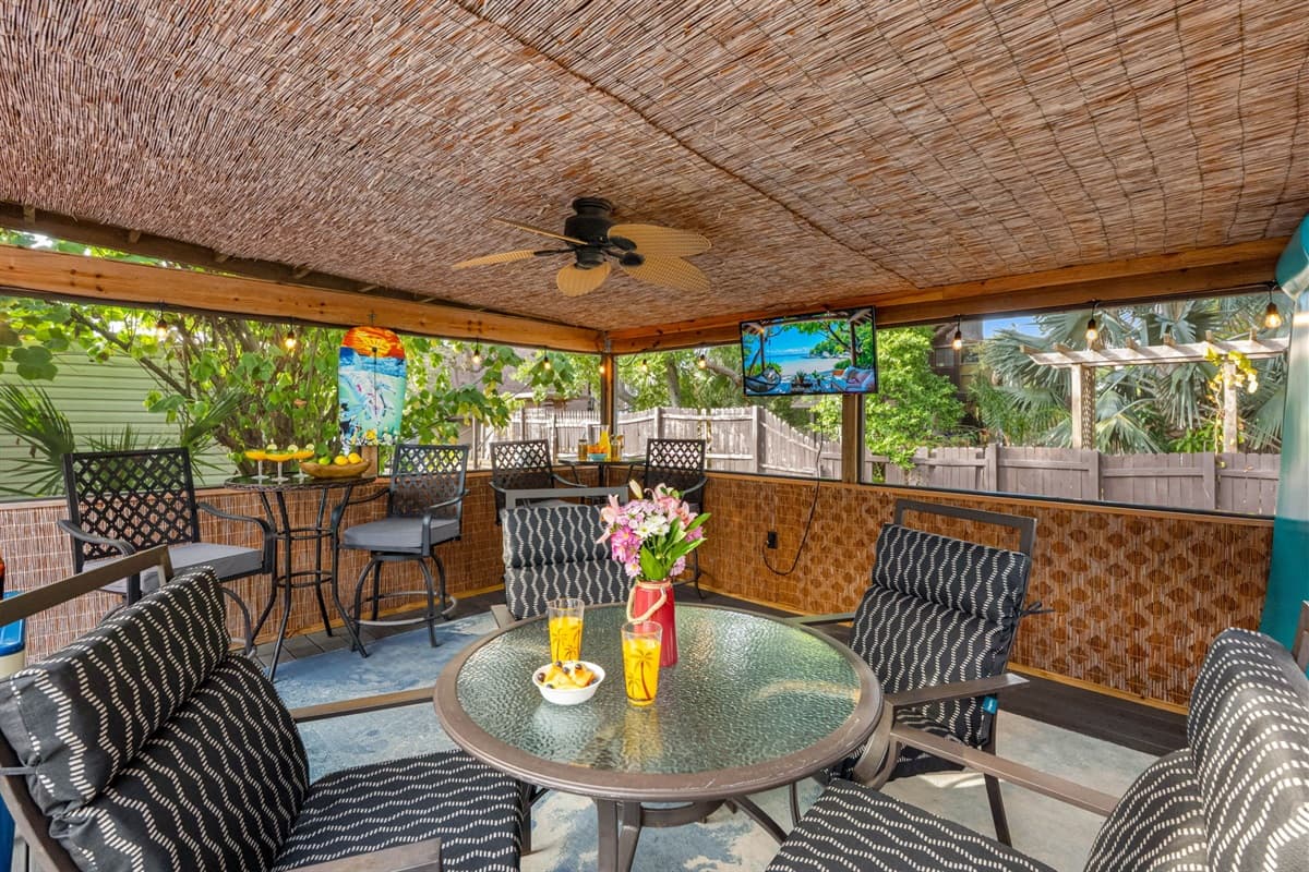 This thoughtfully curated patio oasis blends comfort and entertainment with a tropical ambiance.