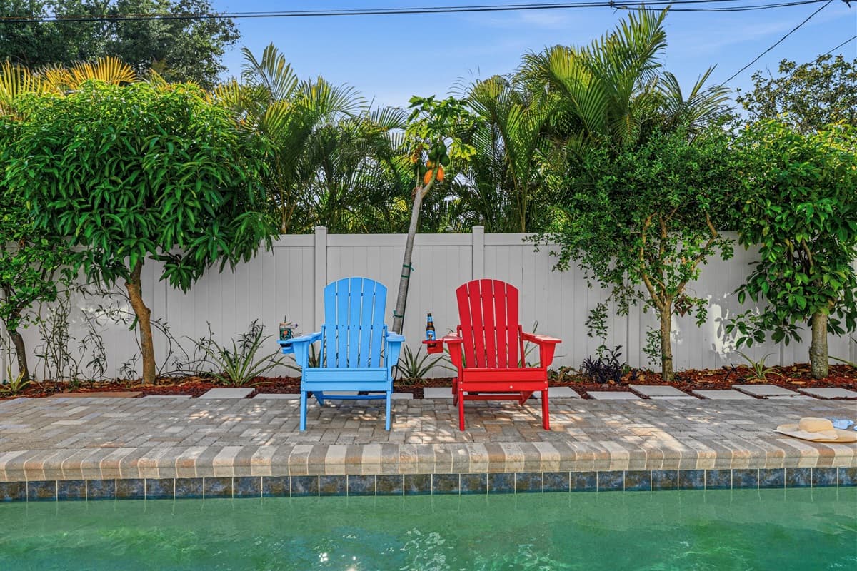 Poolside lounge area with bright chairs and lush greenery—ideal for soaking up the Florida sunshine 