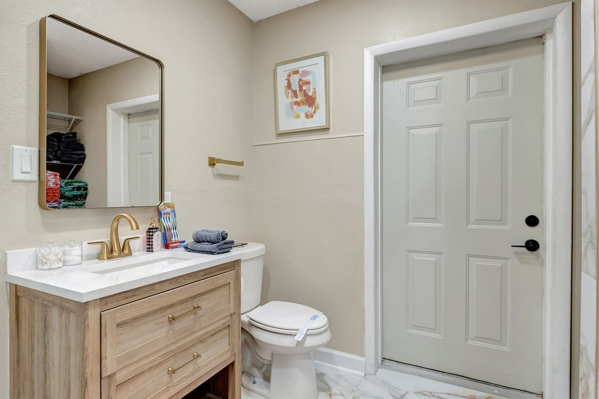 Step into pure elegance and refinement in our bathroom, where creamy marble and gilded accents come together to create a sanctuary of opulence.