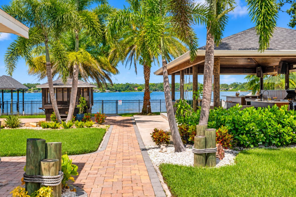 Blend indoor comfort with outdoor charm in this covered kitchen and seating area, set against a backdrop of sparkling water views.