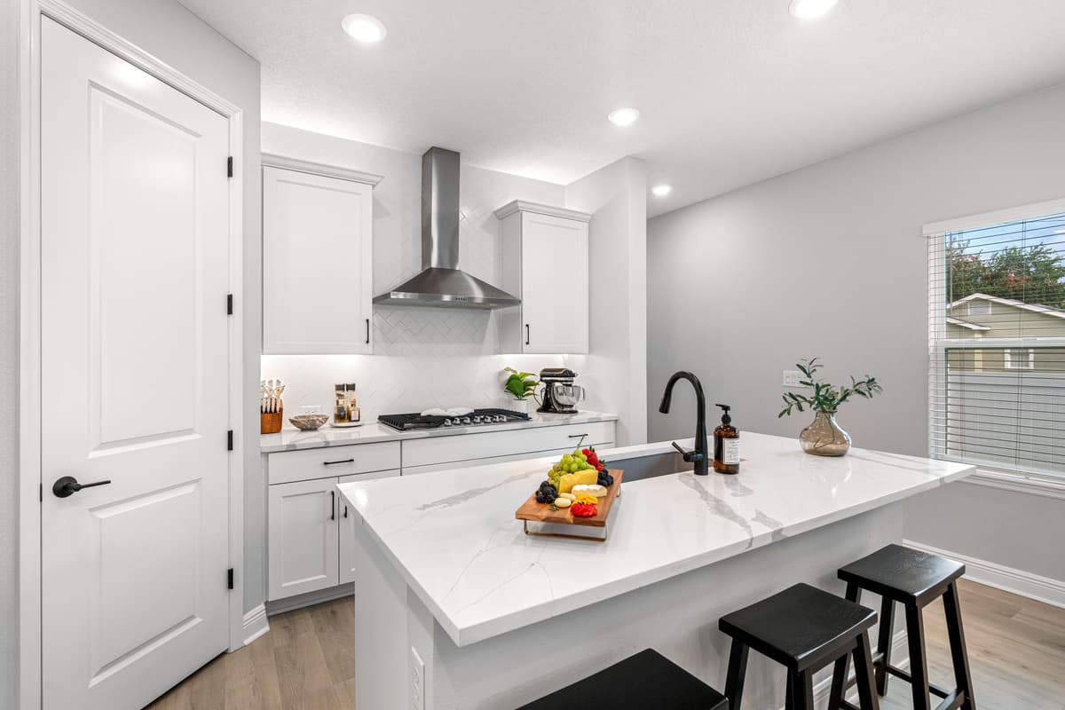 The sleek white cupboards are complemented by pristine white countertops, providing a clean and minimalist aesthetic that enhances the space's overall appeal.
