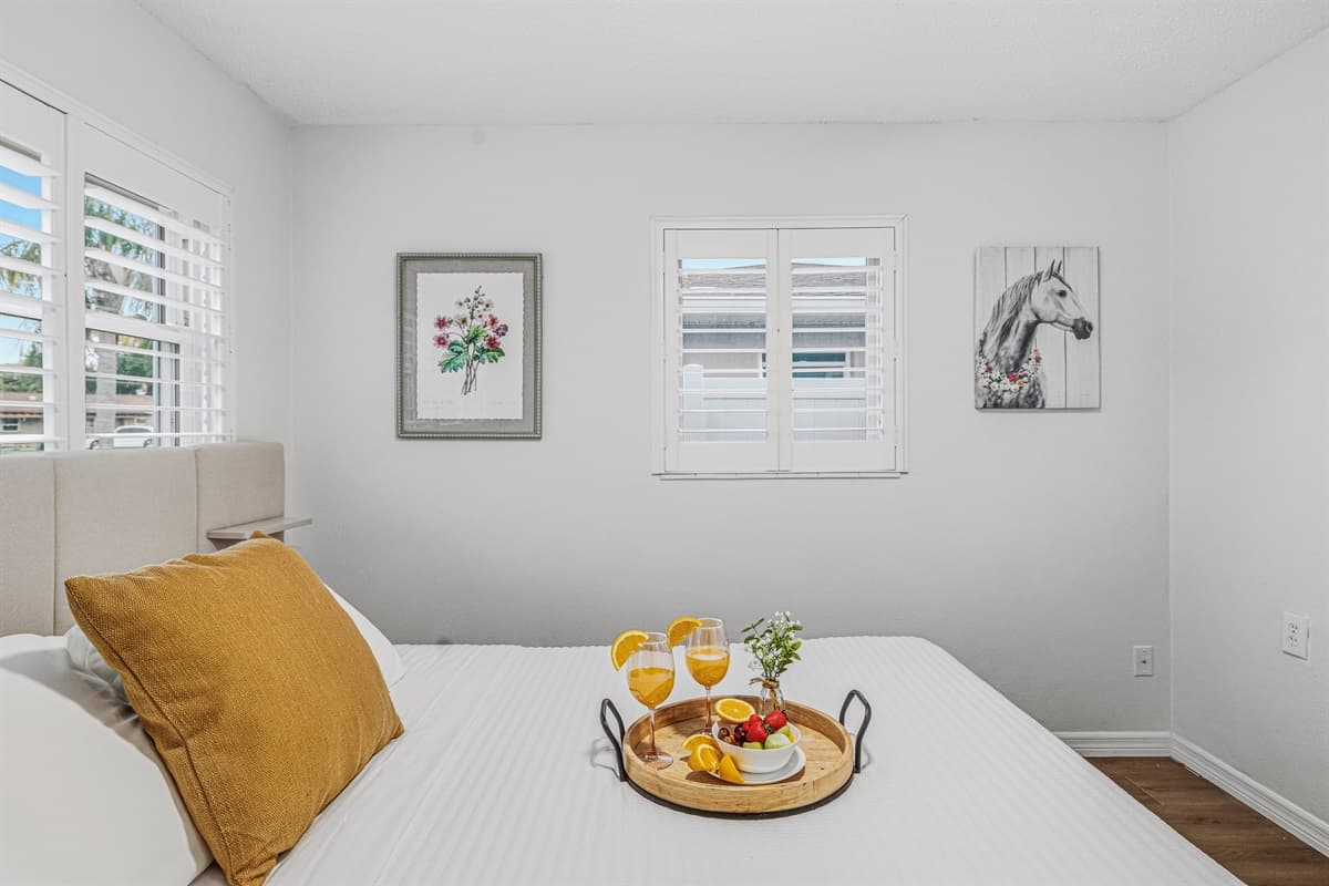 Close-up of king bed with decorative accents and cozy styling—perfect for unwinding after a long day 
Tray and food setup shown are for staging purposes only and are not included.