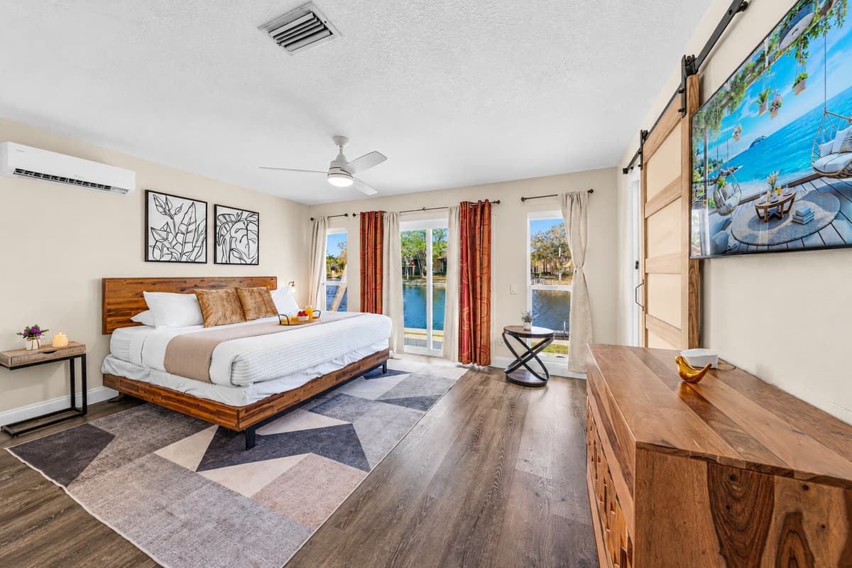 Relax in the spacious primary bedroom featuring a king bed and peaceful waterfront views.