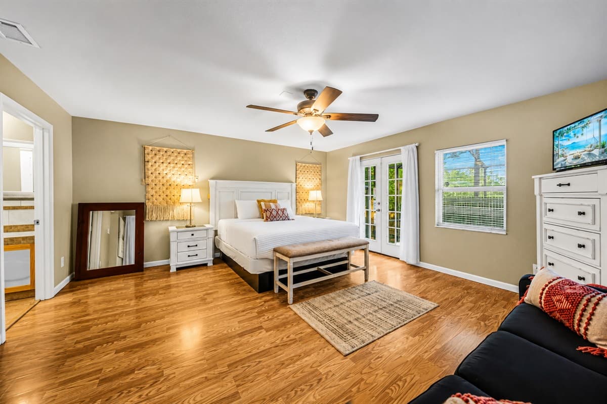 Bright and airy master suite with cozy seating, hardwood floors, and plenty of natural light.