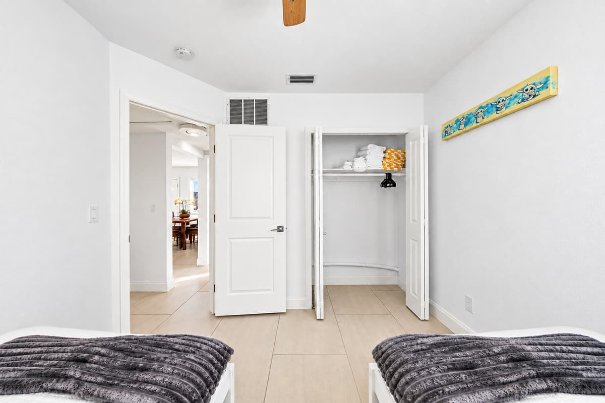 Spacious twin bedroom with closet storage and convenient access to the hallway.