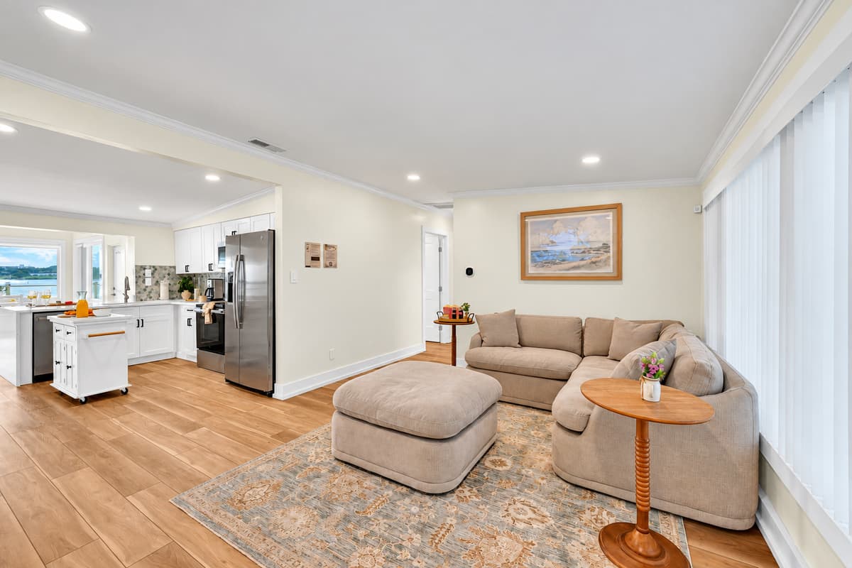 A second living room for cozy nights. A soft beige sectional, ottoman and rug create a quiet den near the kitchen. Perfect for movies or a nap.