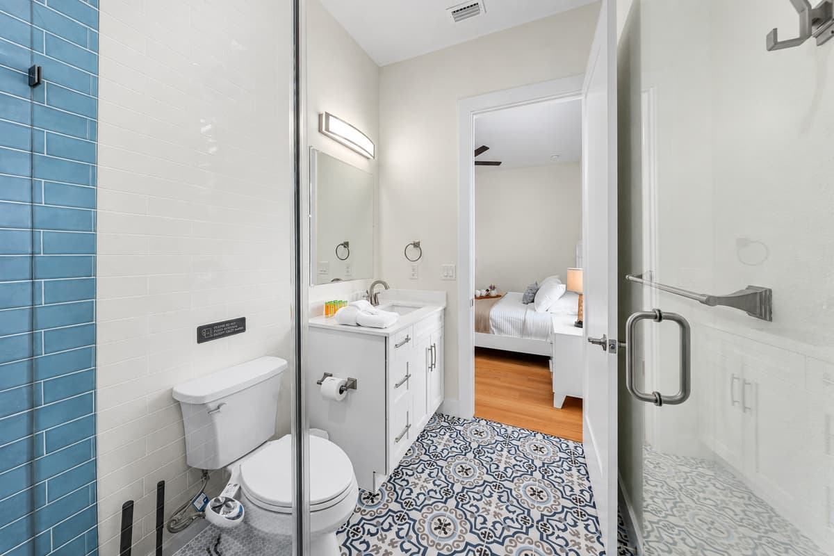 Bathroom 1 (en suite): glass walk-in shower, vanity, and toilet.