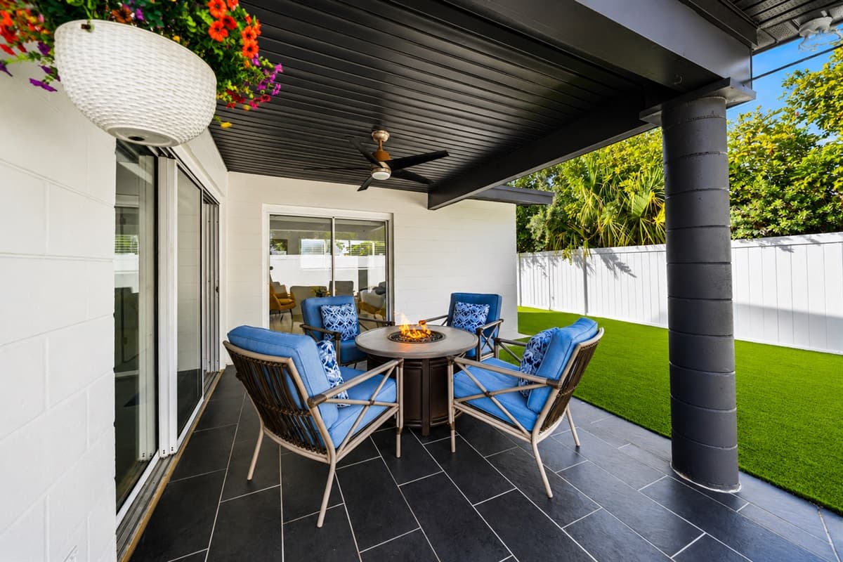 Covered patio seating area with modern outdoor furniture and backyard access.