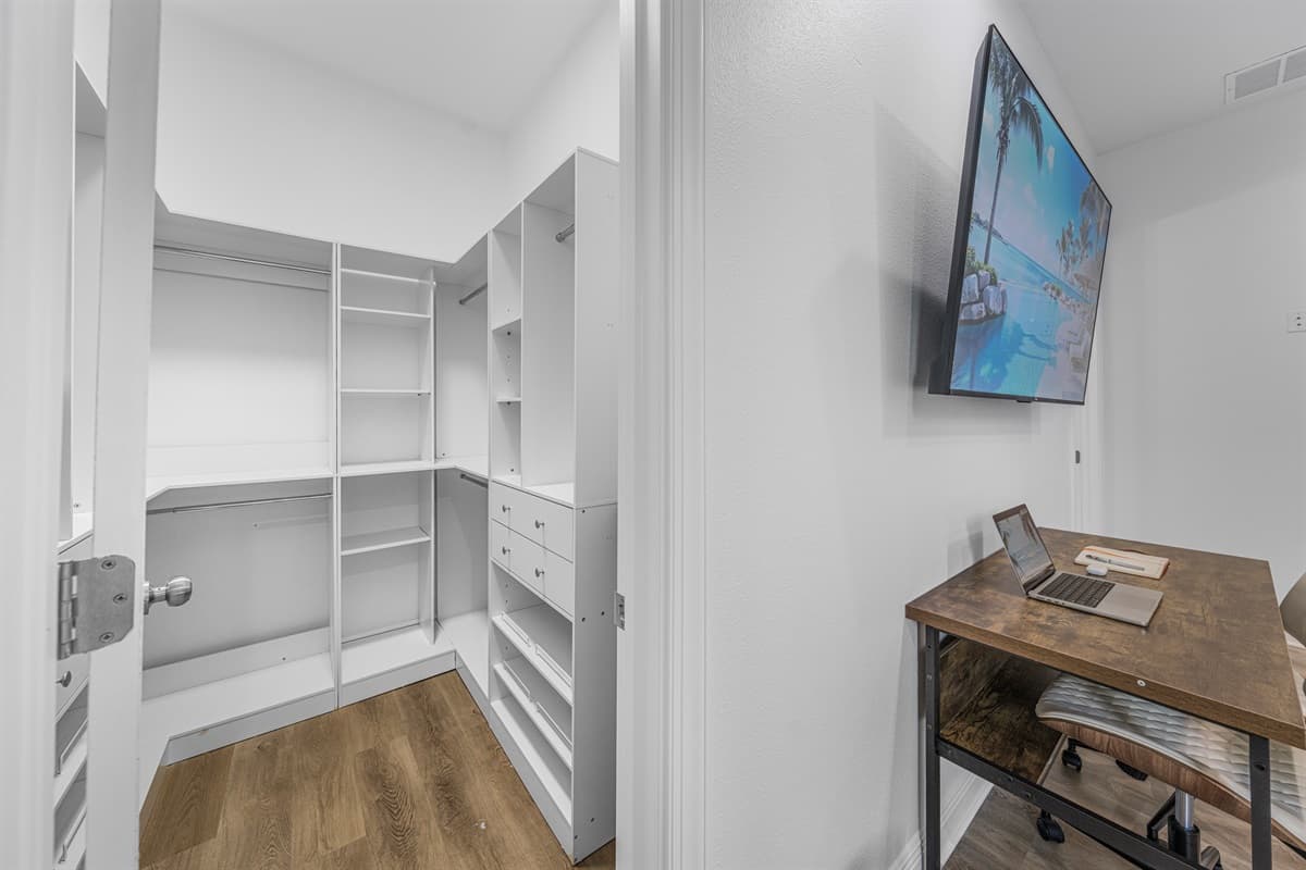 Walk-in closet with built-in shelving, offering ample storage for your stay.