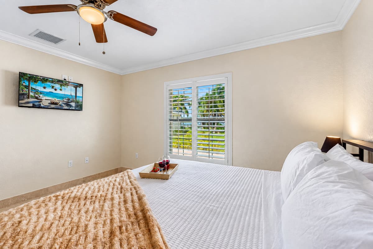 A large window with plantation shutters fills the room with light, enhancing its clean lines and simple elegance.