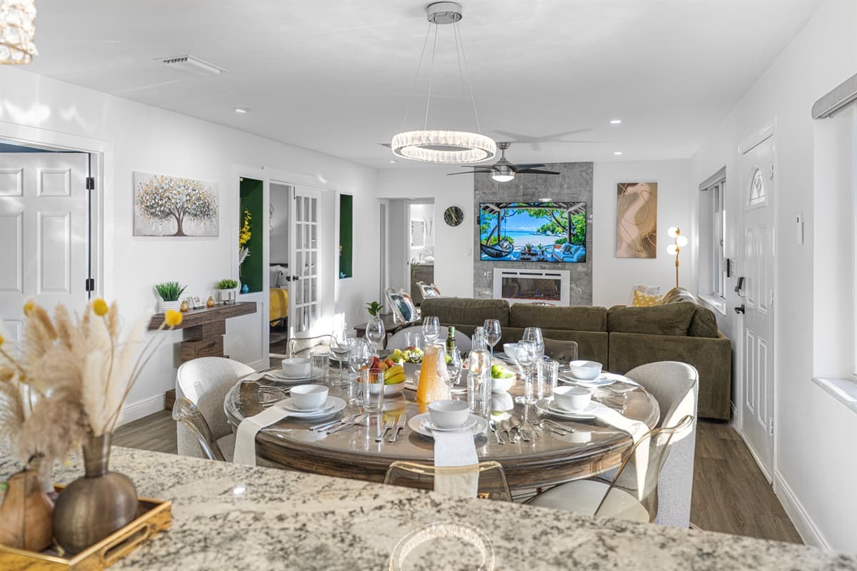 A bright and elegant dining area designed for memorable meals, featuring a spacious table, stylish seating, and beautiful lighting overhead.