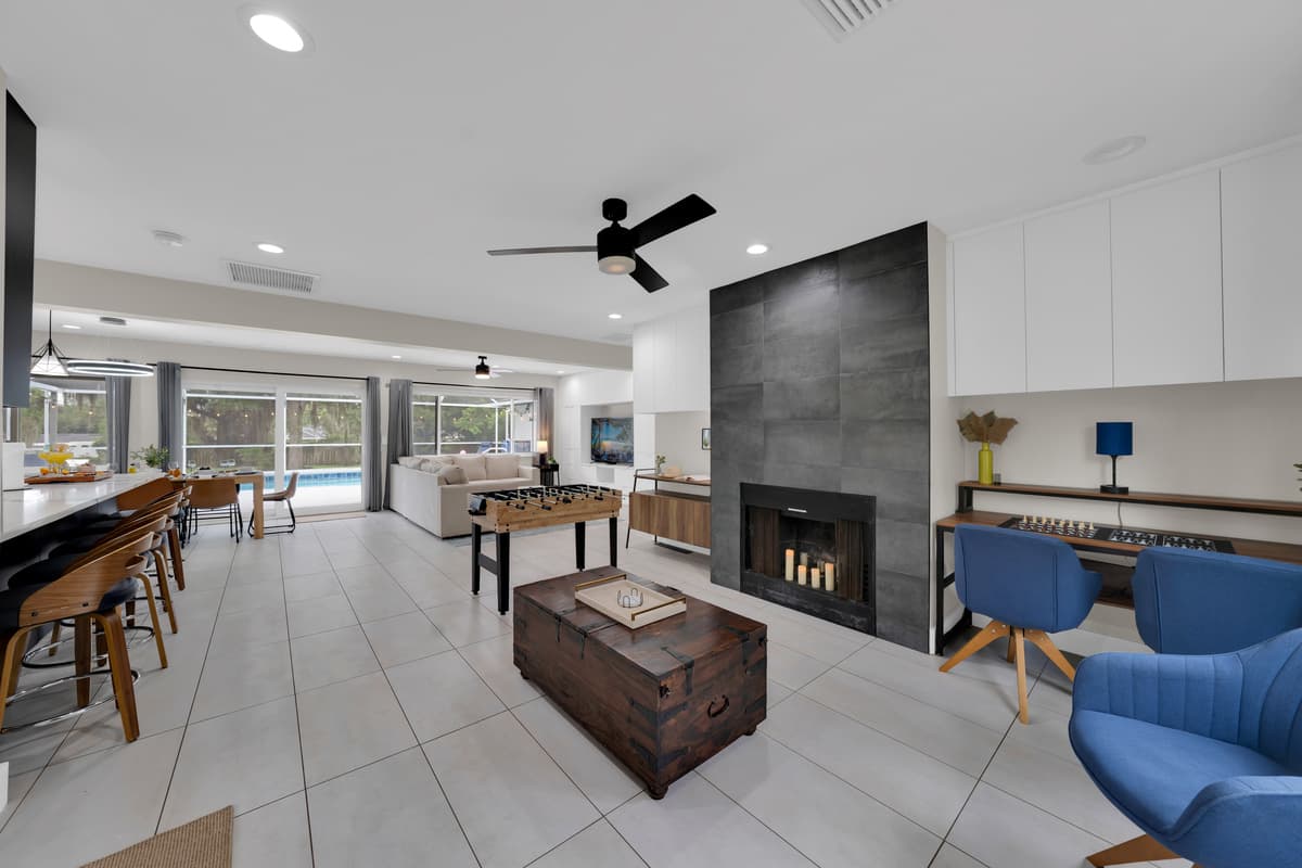 The perfect first impression: a warm living space with a cozy fireplace, generous seating, and views stretching all the way to the pool.