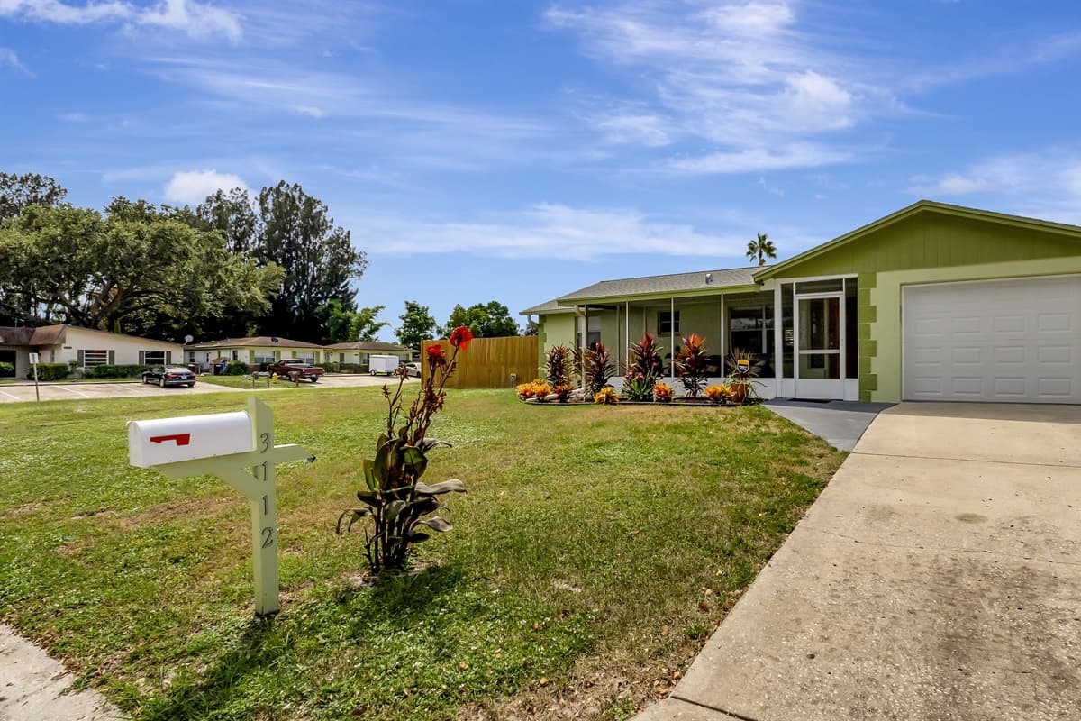 The front yard's enchanting green expanse and expansive driveway..