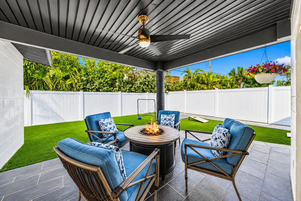 Spacious backyard patio with fire table, outdoor seating, and private fenced yard.