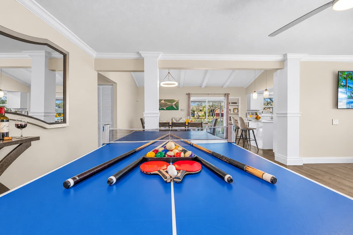 Spacious recreation area with pool table and seamless access to the kitchen and dining room.