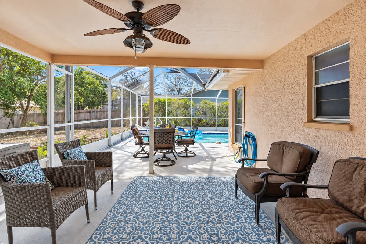 Adjacent to the pool, the covered patio features a dining table and seating, making it an ideal spot for casual family meals, and lively conversations.