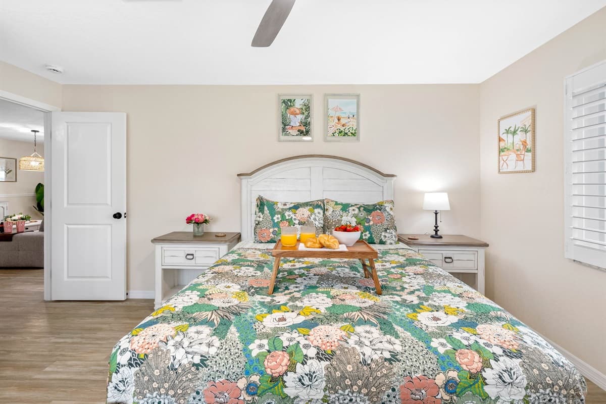 With its clean lines, light flooring, and floral bedding, this bedroom offers a perfect blend of style and comfort.
