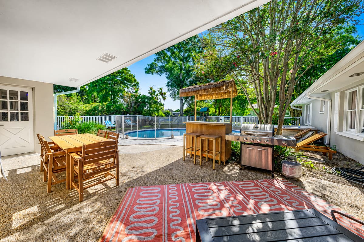 Bar stools, dining table, and the water in view from every seat. Lunch outside becomes the default.