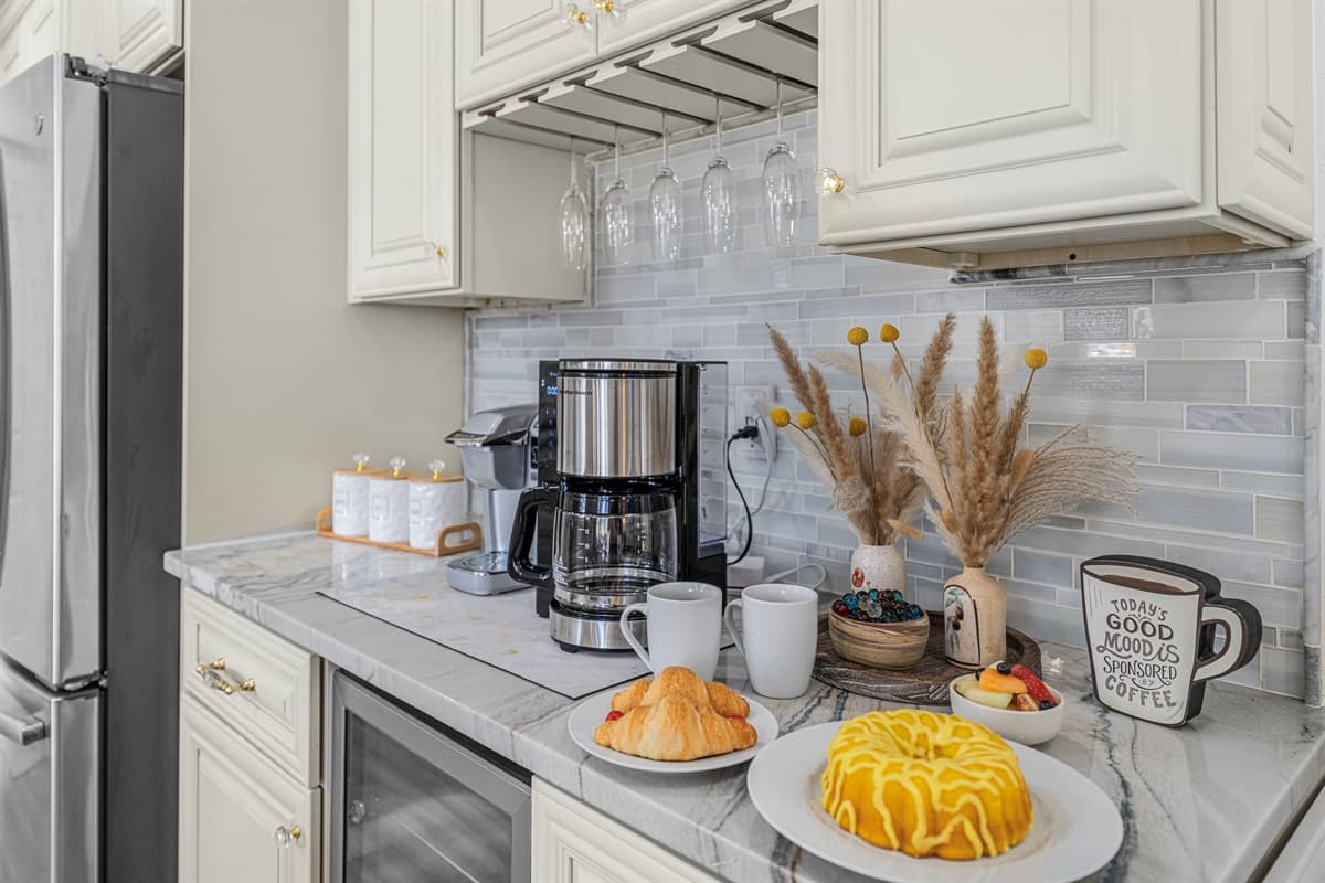 Start your mornings at this charming coffee station, thoughtfully set up with a coffee maker, mugs, and a cozy countertop space to ease into the day.