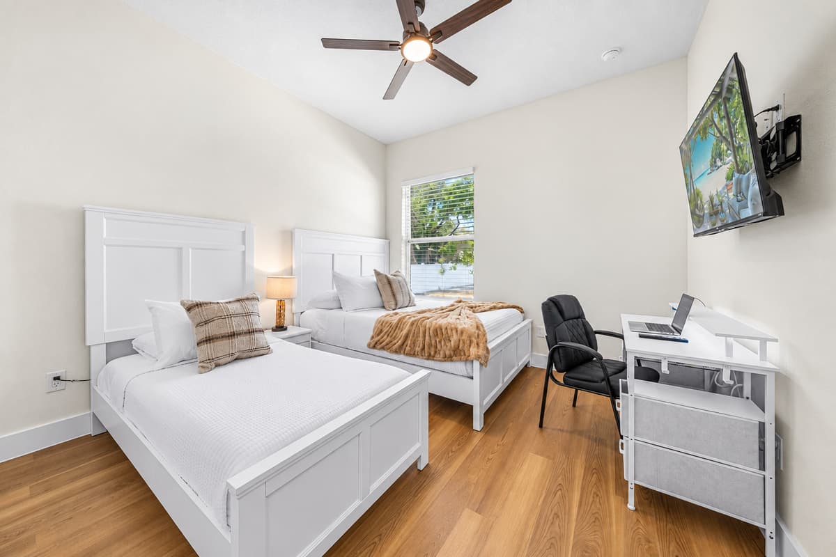 Spacious bedroom with two beds and workspace—perfect for groups or extended stays.