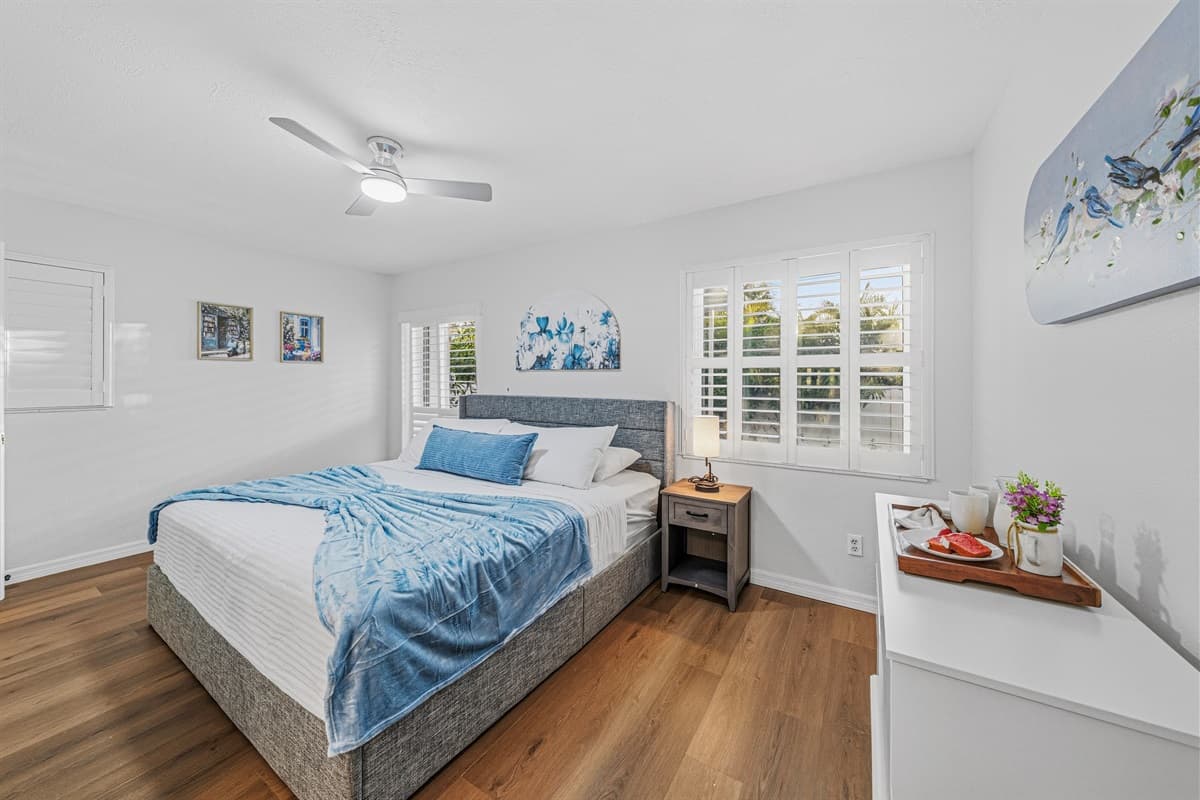 Bright and cozy bedroom featuring a king-size bed, natural light, and clean, modern décor 