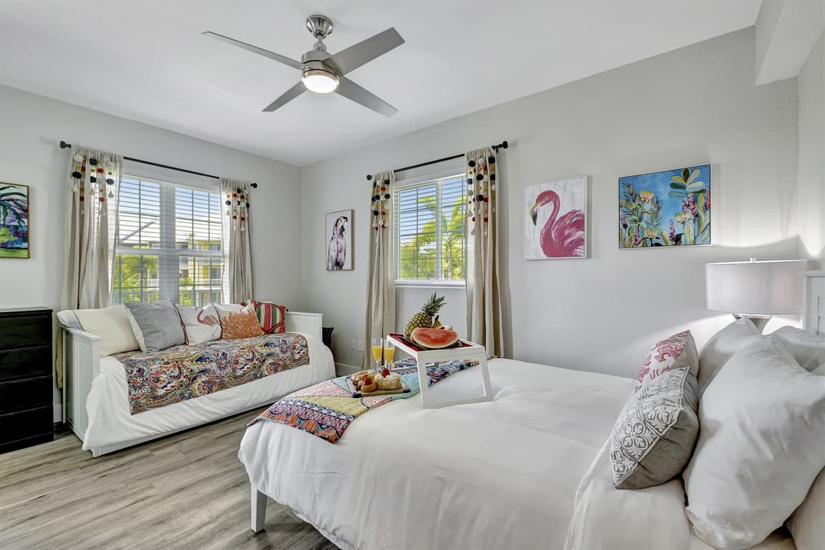 A charmingly decorated bedroom featuring both a queen-size and a twin-size bed.