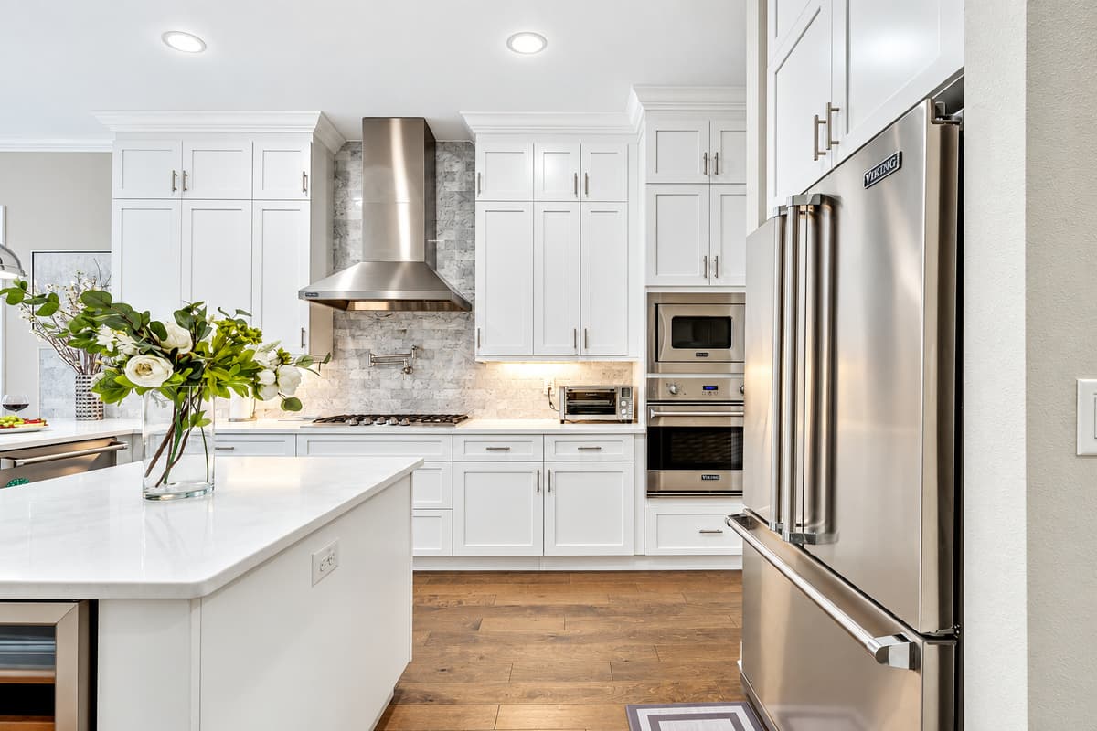 This thoughtfully curated space features sleek white cabinets that offer ample storage, paired with modern appliances that cater to all your cooking needs.