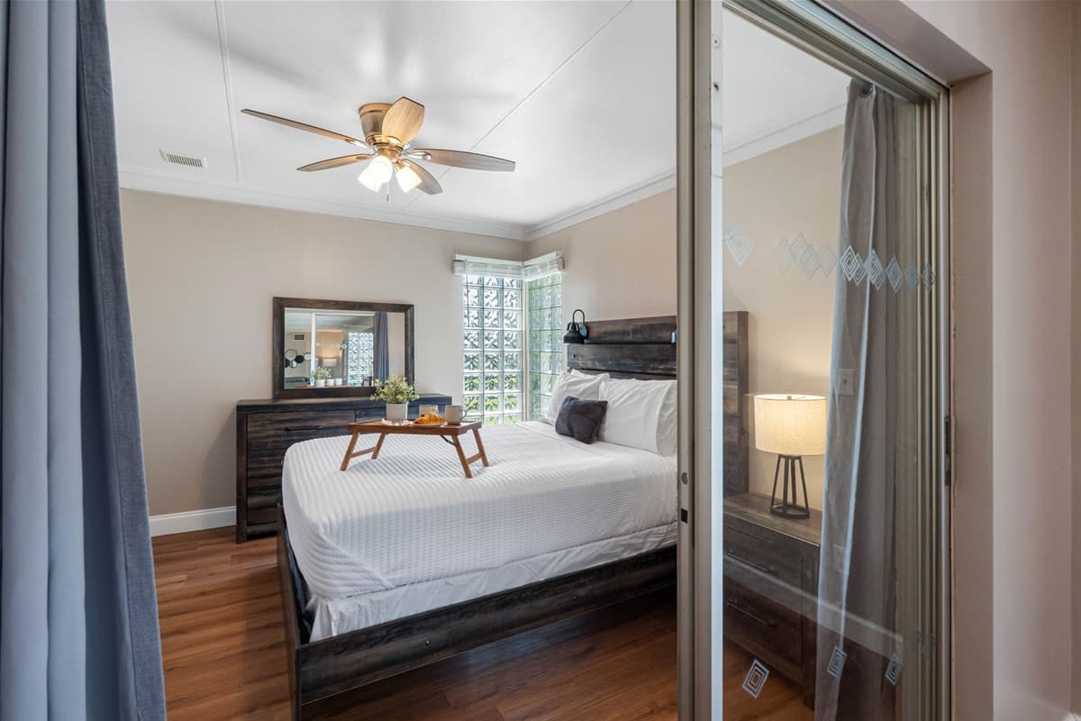 Large windows and glass accents allow plenty of natural light to flow in, giving the room a bright and refreshing feel.