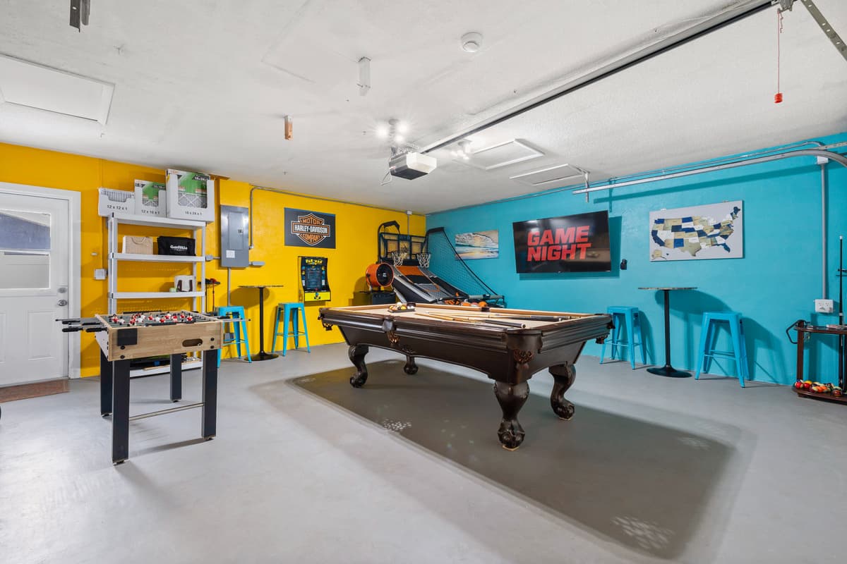 Game room with pool table and arcade games.