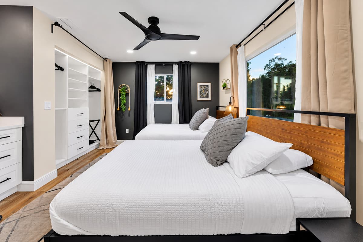 Sleeps four, feels like a private suite. Two queens, warm wood accents, blackout-ready curtains and a garden view — a room that works as well for grandparents as it does for four friends.
