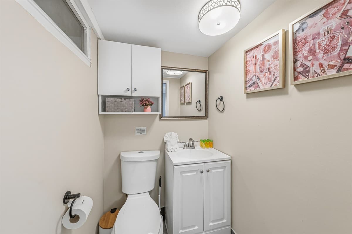 Clean half bathroom with vanity, mirror, and essentials for your stay.