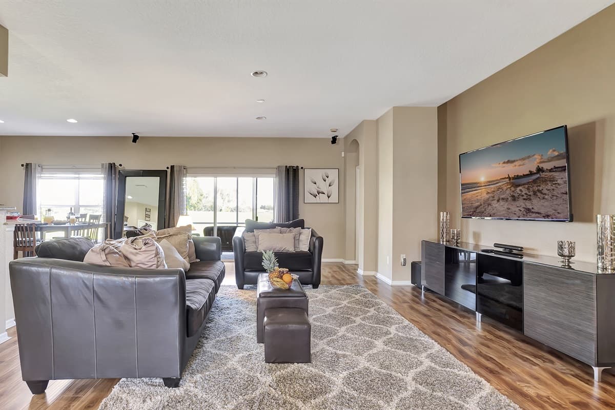 Oversized windows flood the room with natural light, offering sweeping views of the outdoors.