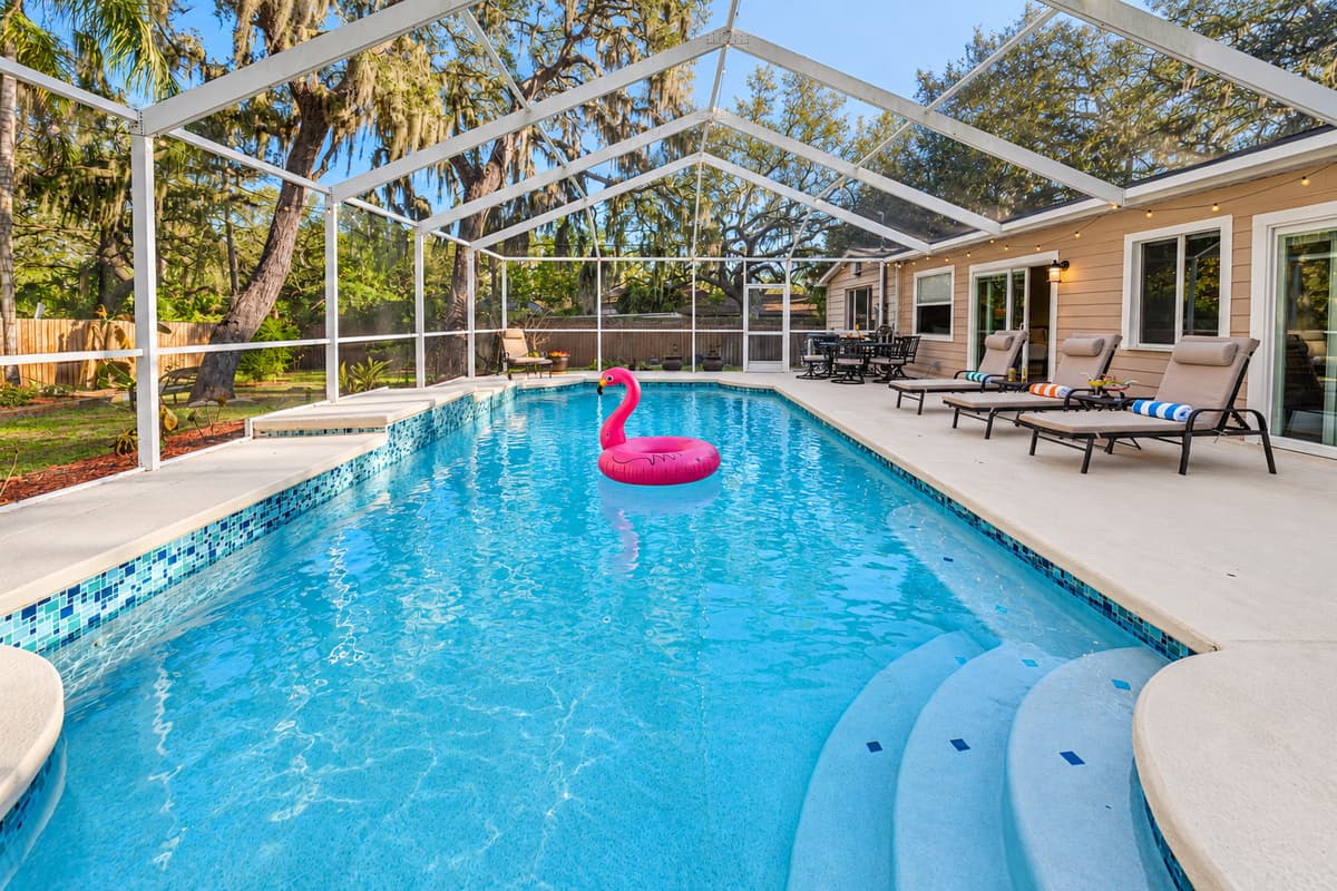 A beautiful panoramic view of the private screened-in pool, surrounded by tranquil wooded scenery that provides both privacy and a relaxing retreat atmosphere.