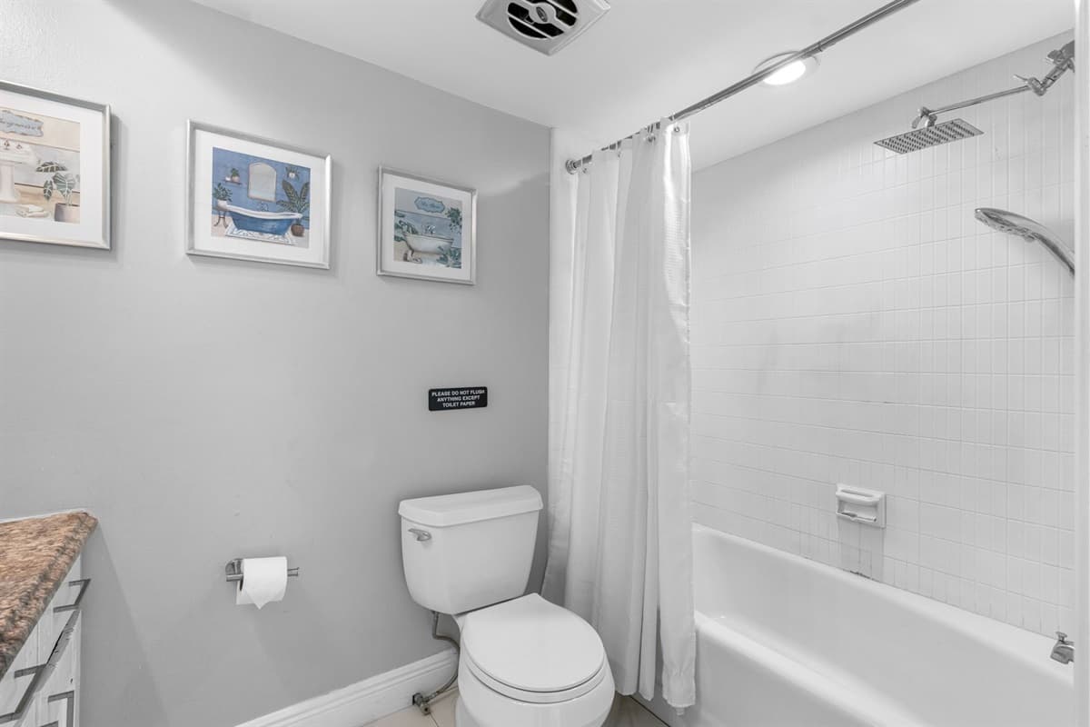 A fresh, modern bathroom featuring a full tub, rainfall showerhead, and soft neutral tones.