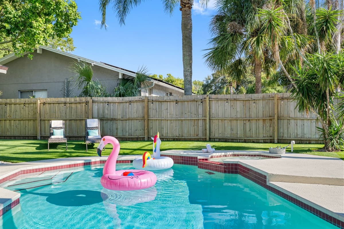 The poolside ambiance is enhanced by the soft sound of water cascading from a nearby fountain, adding to the peaceful environment.