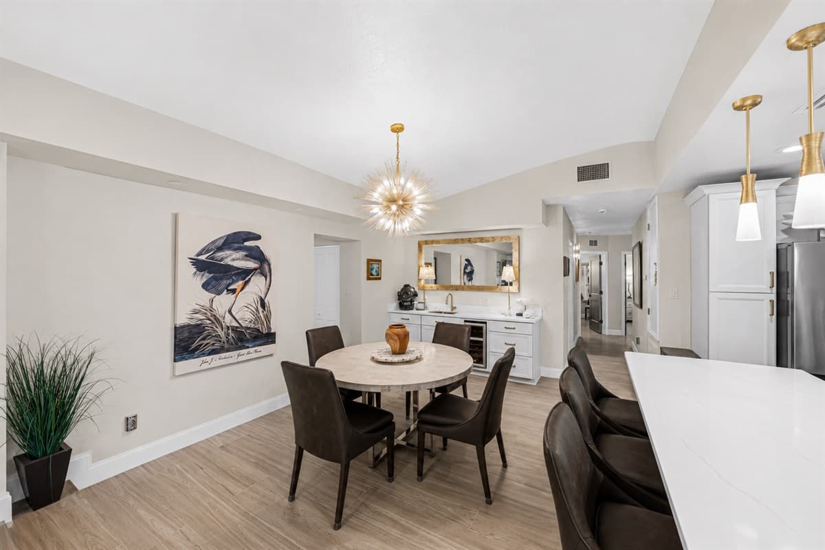 Stylish dining space with round table seating conveniently connected to the modern kitchen and living area.