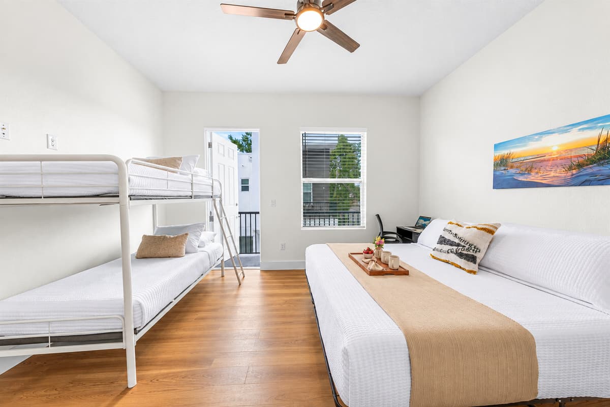 The room the kids will fight over. Bedroom 3 pairs a king bed for the grown-ups with a bunk bed the kids will race to claim, plus balcony access. Everyone sleeps under one roof, up to 9 guests in total.