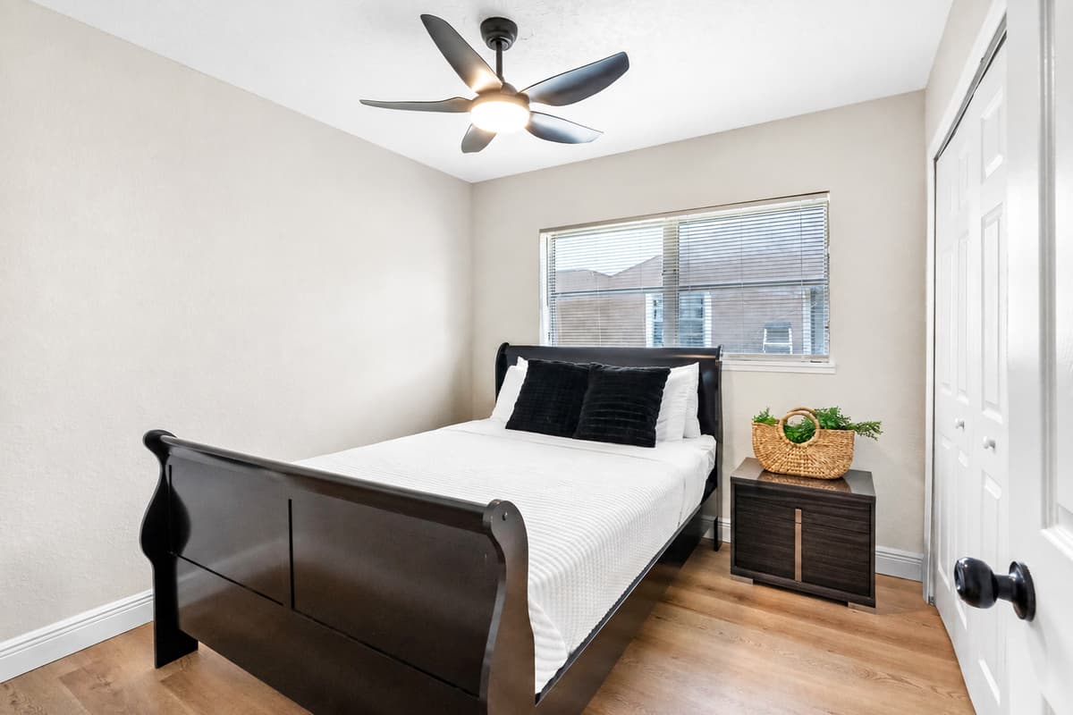 At the center of the room is a striking dark wood sleigh bed, offering a timeless and elegant silhouette.