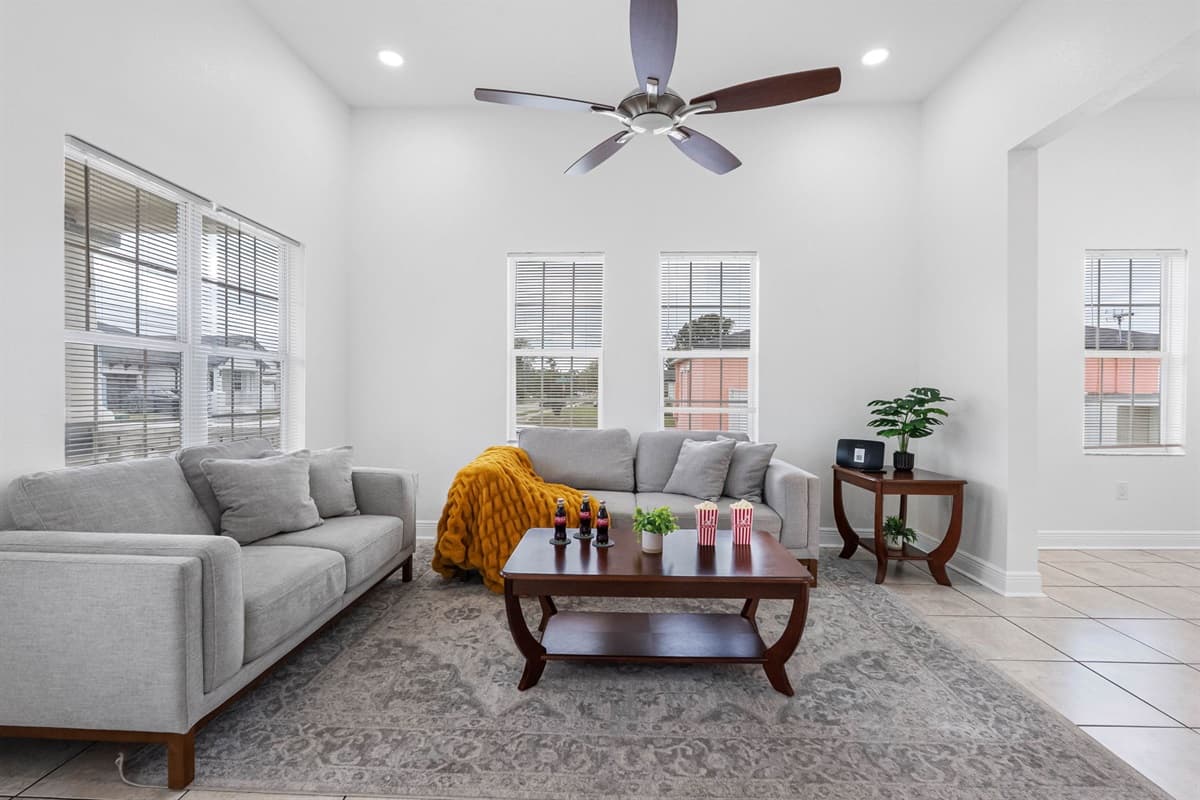 This bright and spacious living room offers comfortable seating, large windows with natural light, and a welcoming layout perfect for relaxing or gathering with family and friends.