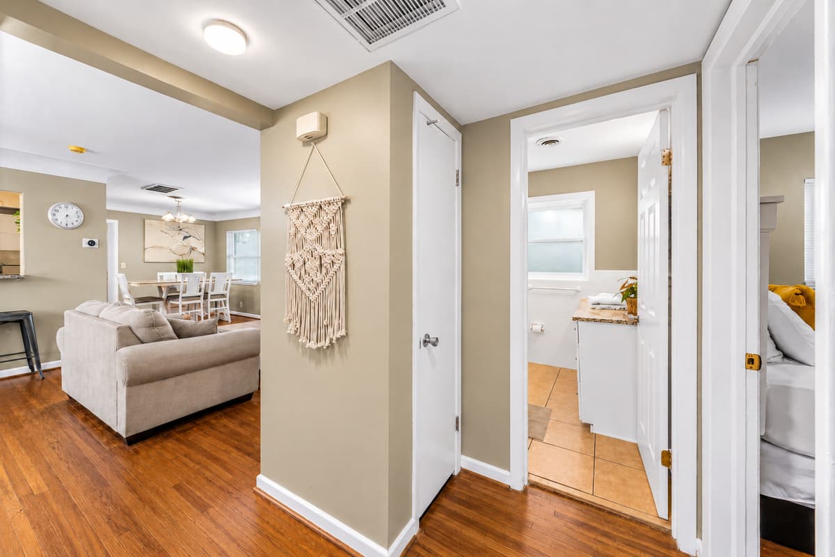 Open hallway and living space with warm wood flooring and easy access to the main common areas.
